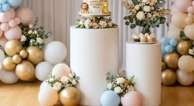 Pastel de cumpleaños sobre cilindros blancos rodeados de globos