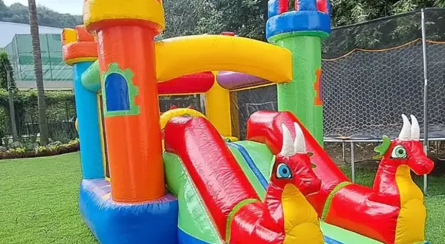 Castillo inflable de colores con dragones rojos