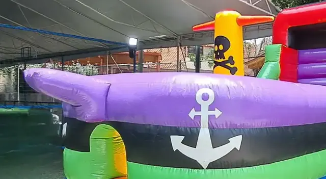 Inflable con forma de barco pirata bajo una carpa