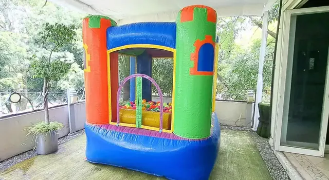 Castillo inflable pequeño instalado bajo techo en una terraza