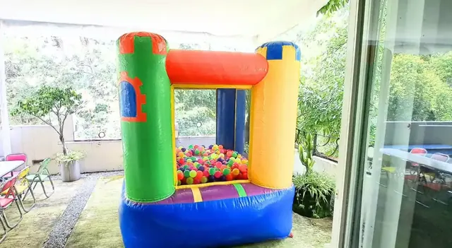 Castillo inflable para bebés instalado junto a un ventanal