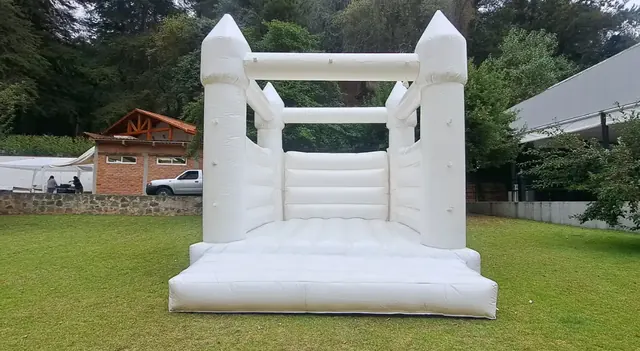 Castillo inflable blanco instalado en un jardín