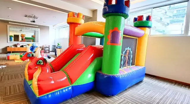 Castillo inflable con dragones rojos dentro de un salón