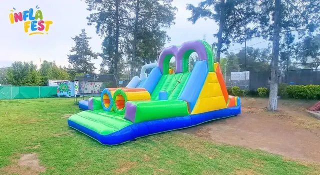 Tobogán inflable instalado en un jardín amplio