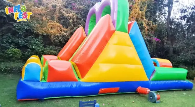 Tobogán inflable de colores instalado en un jardín