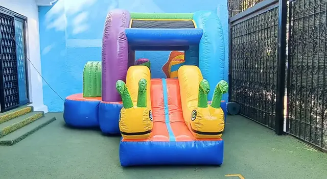 Inflable GUSANITOS visto de frente, con dos gusanitos amarillos a los lados de la resbaladilla
