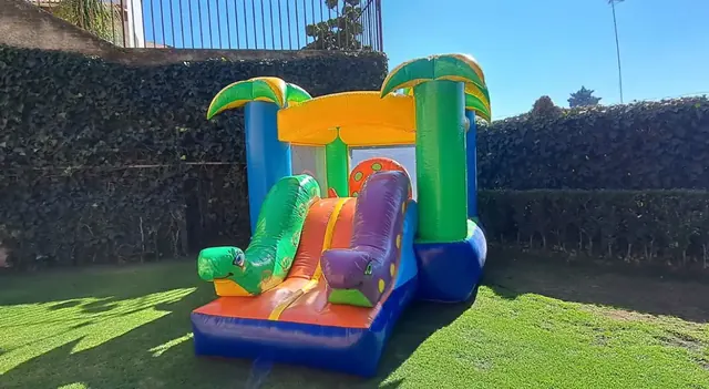 Inflable mediano con palmeras instalado en un jardín