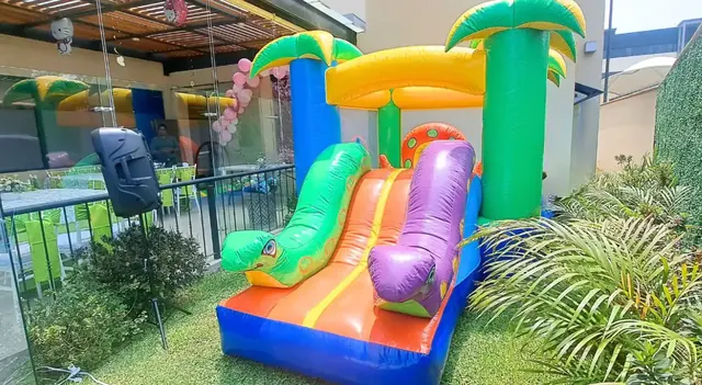 Inflable con palmeras y resbaladilla instalado en una terraza